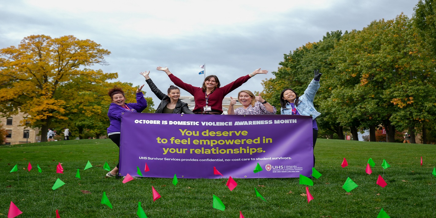 UHS Staff with a banner for Domestic Violence Awareness Month