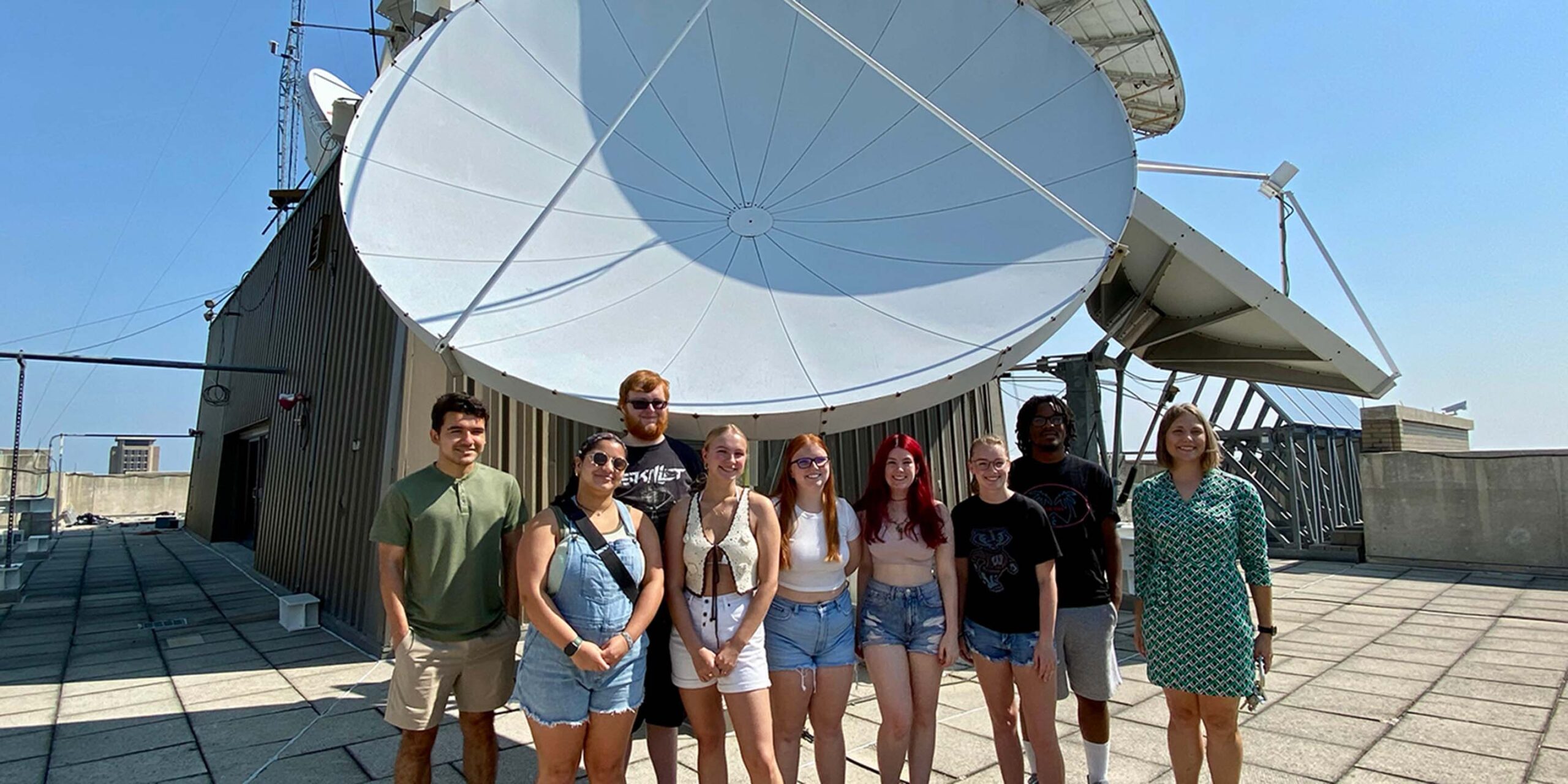 Students next to a satellite
