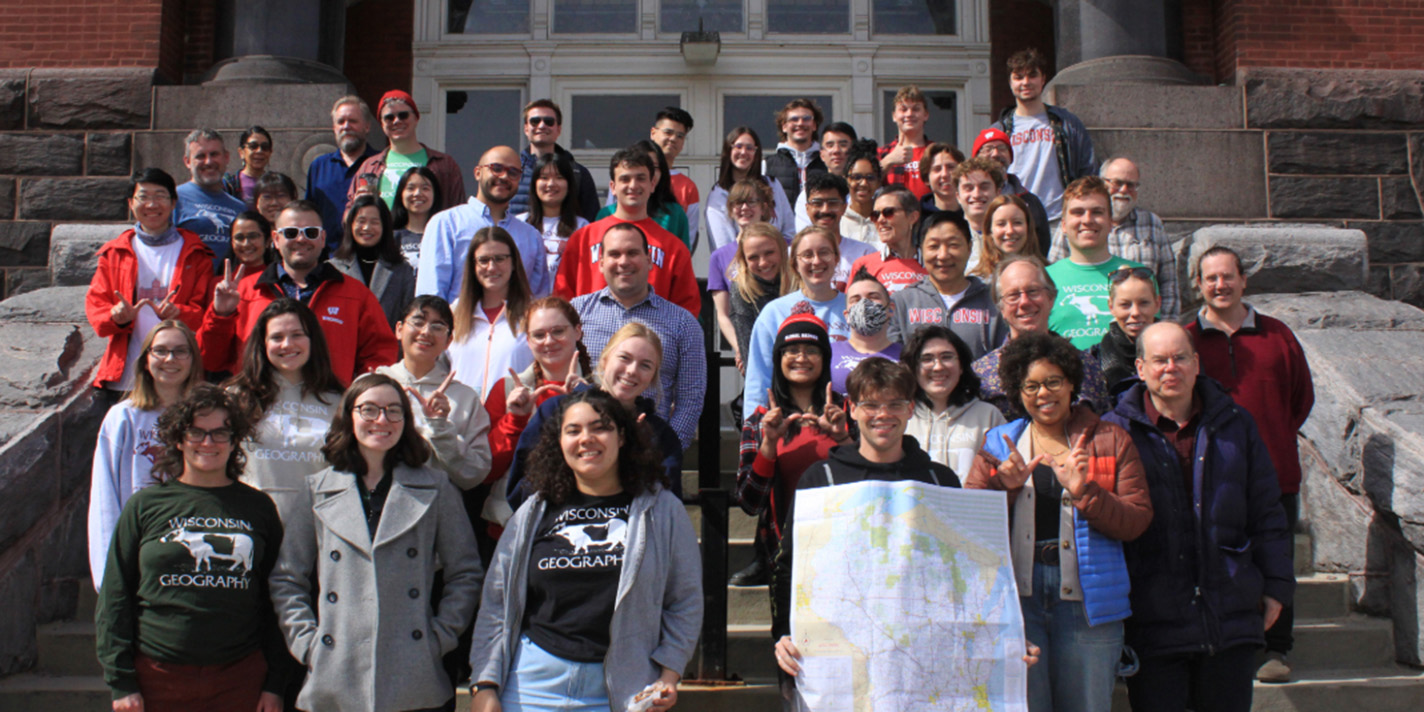 Students pose with a map of Wisconsin