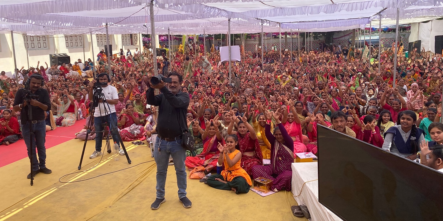 People shown sitting on the ground
