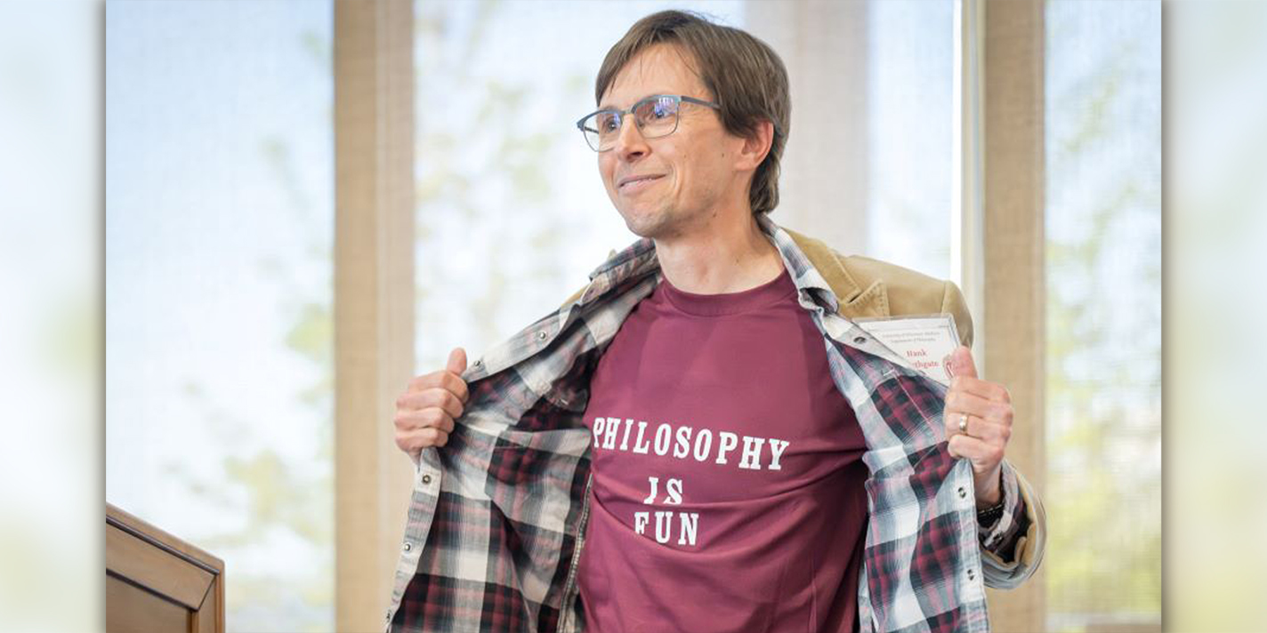 Philosophy professor shown with a shirt reading "Philosophy is fun"