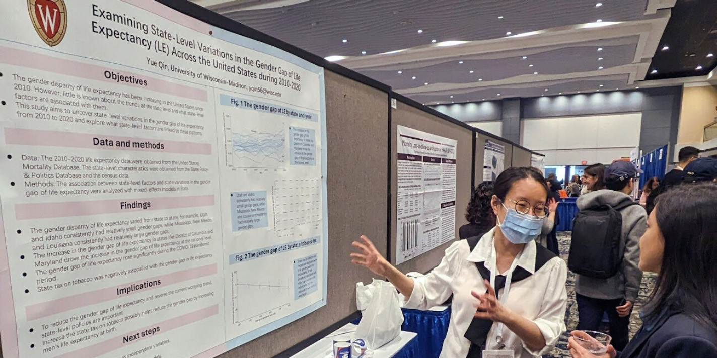 Student presenting their work on a poster board